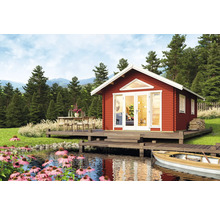 Rotes Holzhaus mit Terrasse und See in einer Waldlandschaft.