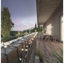Lichterkette auf einer Terrasse mit Gartenblick