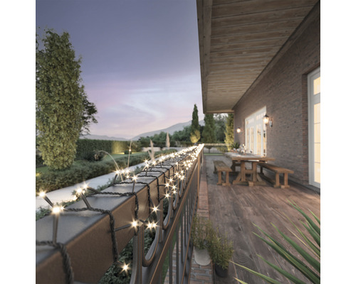 Lichterkette auf einer Terrasse mit Gartenblick