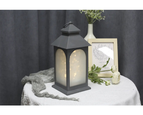 Dekorative Laterne mit Sternenlichtern als Tischdekoration.