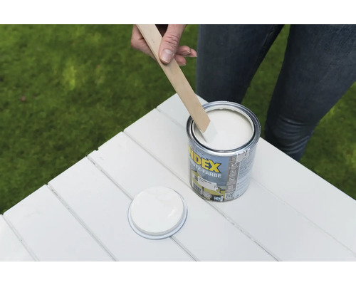 INDEX Lackfarbe mit Rührholz auf weißem Holztisch