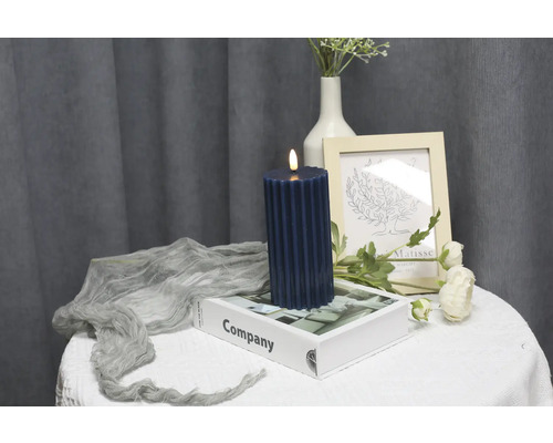 Dekorative LED-Kerze auf einem Tisch mit Deko-Elementen