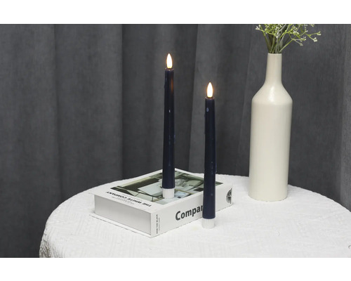 Dekorative LED-Kerzen auf einem Tisch mit Buch und Vase