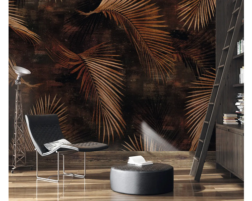 Dekorative Wandgestaltung mit braunen Palmenblättern, Sessel, Stehlampe und Bücherregal mit Leiter in einem Wohnzimmer