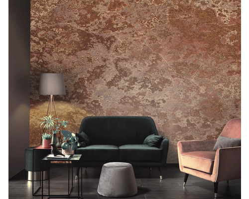 Wohnzimmer mit einer Wandtapete in Steinoptik, einem Sofa, einem Sessel, einem Hocker und einer Stehlampe