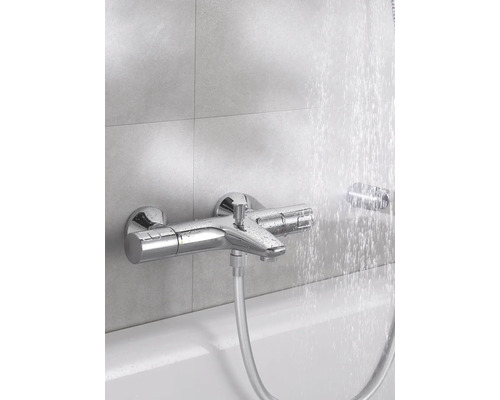 Aufputz-Badewannenarmatur mit Duschschlauch und laufendem Wasser.