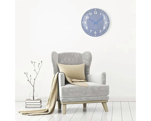 Wohnzimmer mit Sessel und blauer Wanduhr