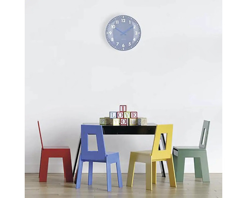 Szene mit Tisch, vier Stühlen und Wanduhr