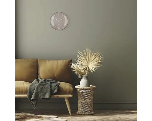 Wohnzimmer mit Sofa, Beistelltisch, Dekoration und runder Wanduhr