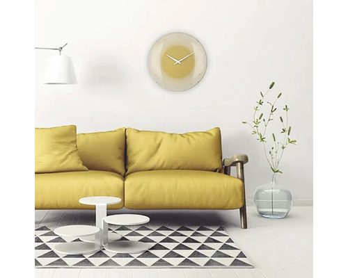 Wohnzimmer mit gelbem Sofa, Couchtisch, Teppich und runder Wanduhr