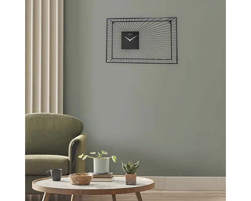 Wohnzimmer mit Sessel, Tisch und rechteckiger Wanduhr