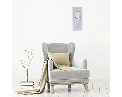 Wohnzimmerszene mit Sessel, Kissen, Decke und rechteckiger Wanduhr