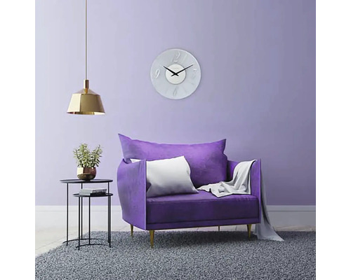 Wohnzimmer mit Sessel, Wanduhr, Stehleuchte und Teppich