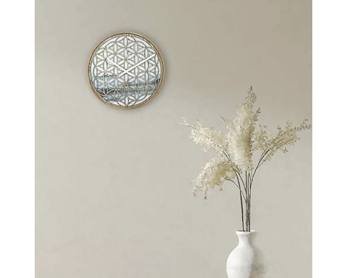 Dekorative Wanduhr mit geometrischem Muster und weißen Ziergräsern in einer Vase