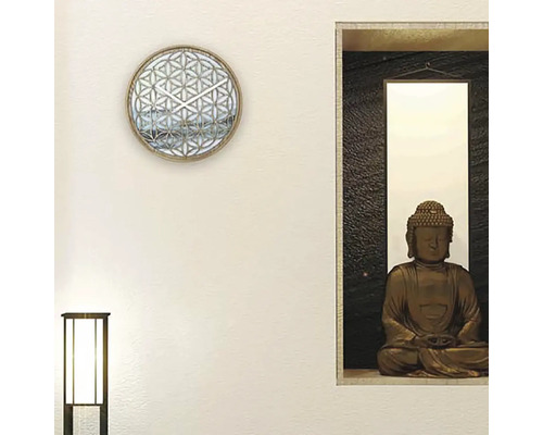 Dekorative Wandgestaltung mit einer Wanduhr und einer Buddha-Statue.