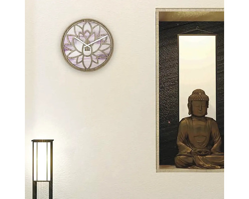 Wohnraum mit Wanduhr im Lotusblüten Design und Buddha Statue