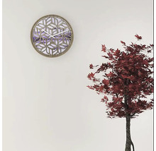 Dekorative Wanduhr mit geometrischem Muster und Quarzuhrwerk an einer Wand.
