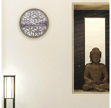 Wanddekoration mit einer Uhr und einer Buddha-Statue in einem Regal