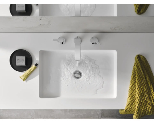 Ansicht von oben Waschbecken mit Armatur, Seife, Handtuch und Hautpflegeprodukt