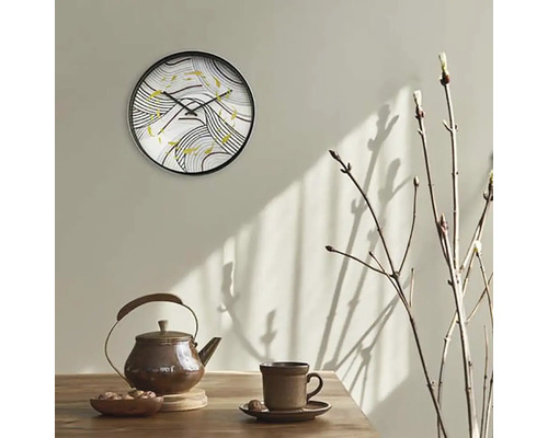 Wanduhr mit abstraktem Muster über Teekanne und Tasse auf Tisch