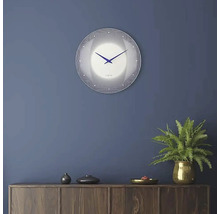 Wanduhr mit Zifferblatt und Zeigern an einer Wand über einem Schrank