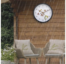 Szene im Garten mit Wanduhr und Korbstühlen bei Regen