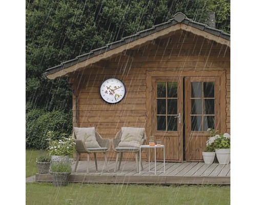 Szene mit Gartenhaus, Gartenmöbeln und einer Wanduhr im Regen.