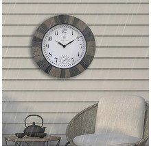 Wanduhr mit Thermometer auf einer Terrasse mit Möbeln