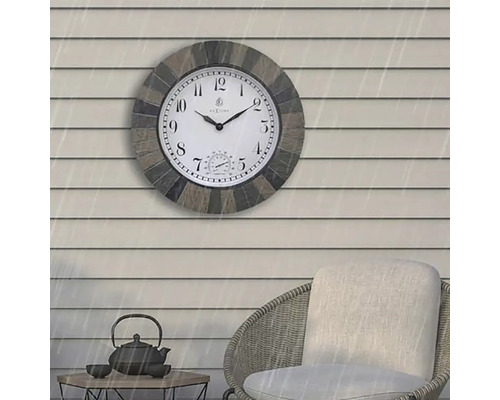 Wanduhr mit Thermometer auf einer Terrasse mit Möbeln