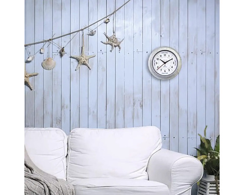 Dekoratives Wohnzimmer mit Wanduhr, Sofa und maritimem Schmuck