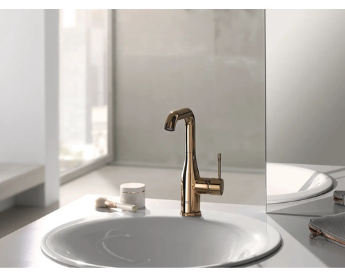 Goldene Waschtischarmatur auf einem Waschbecken im Badezimmer.