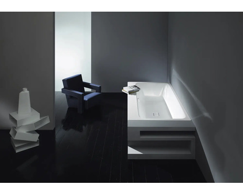 Badezimmer mit Badewanne, Stuhl und Dekoration auf dunklem Holzboden