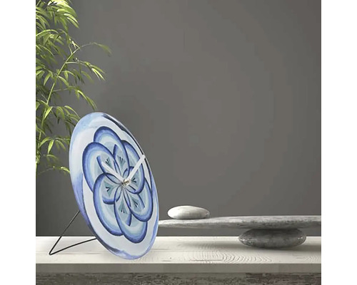 Dekorative Tischuhr mit blauem Blütenmuster auf einem Tisch