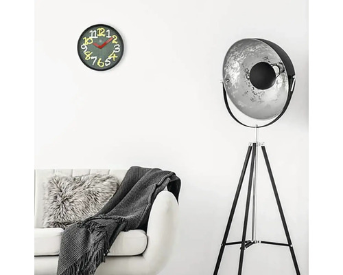 Wohnzimmer mit Sofa, Stehlampe und Wanduhr