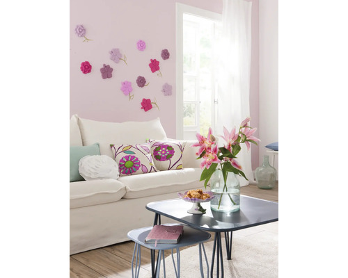 Wohnzimmer mit Sofa, Tisch und Blumendekoration an der Wand