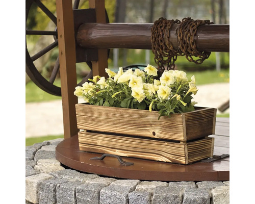 Brunnen mit Holzkübel und gelben Blumen als Gartendekoration