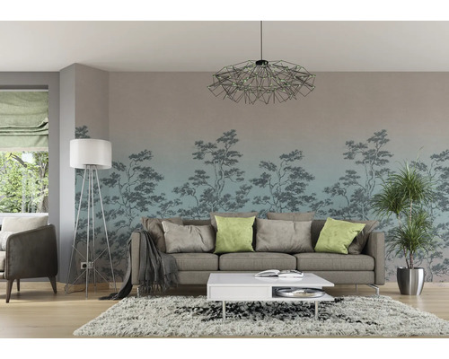 Wohnzimmer mit Sofa, Couchtisch, Stehlampe, Zimmerpflanze und Fototapete mit Baum-Motiv.