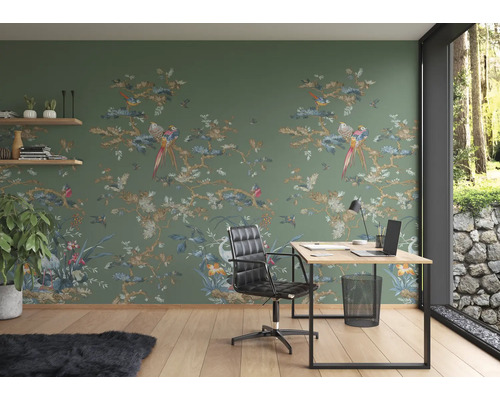 Arbeitszimmer mit grüner Tapete mit Vogelmuster, Schreibtisch und Bürostuhl.
