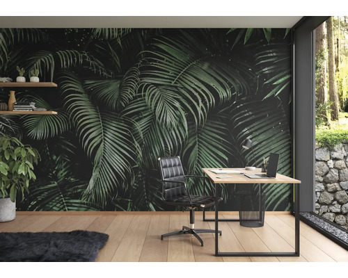Arbeitszimmer mit Fototapete mit Palmenmuster, Schreibtisch und Bürostuhl.