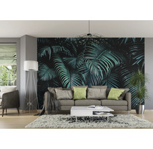 Wohnzimmer mit Fototapete, die üppige grüne Blätter zeigt, ergänzt durch eine Stehlampe und ein graues Sofa