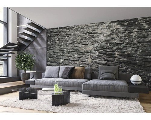 Modernes Wohnzimmer mit grauer Couch, Steintreppen und Steinwand