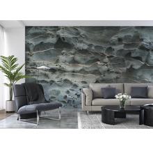 Wohnzimmer mit einem Sofa, einem Sessel und einer Fototapete mit Steinmuster