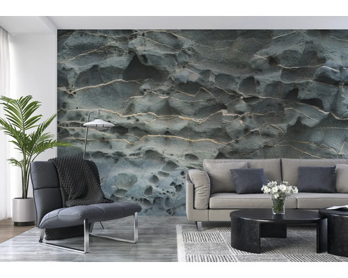 Wohnzimmer mit einem Sofa, einem Sessel und einer Fototapete mit Steinmuster