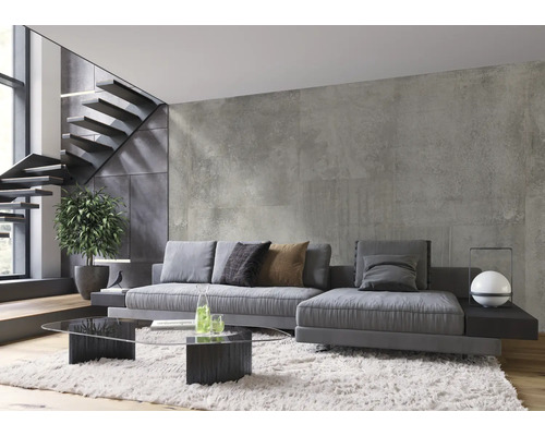 Wohnzimmer mit grauem Sofa, Glastisch und Treppe