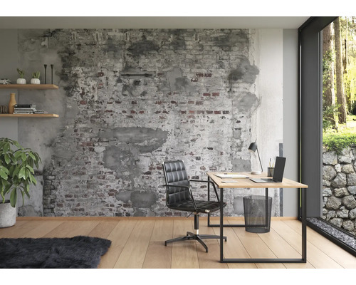 Büro mit Schreibtisch, Bürostuhl, Pflanze und dekorativer Ziegelwandtapete