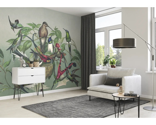 Wohnzimmer mit Vogel-Tapete, Sessel, Teppich und Beistelltisch