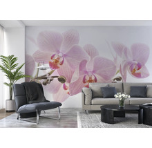 Wohnzimmer mit Wandbild mit Orchideenmotiv, Sessel, Sofa und Tisch.