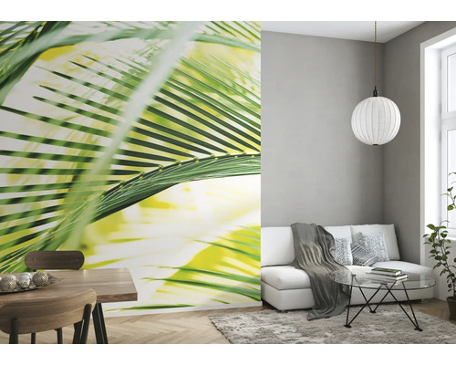Wohnzimmer mit Fototapete mit Palmenmotiv, Sofa und Esstisch