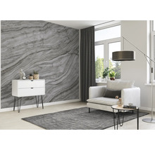 Wohnzimmer mit Marmortapete, Sessel, Kommode und Teppich für eine helle, moderne Atmosphäre
