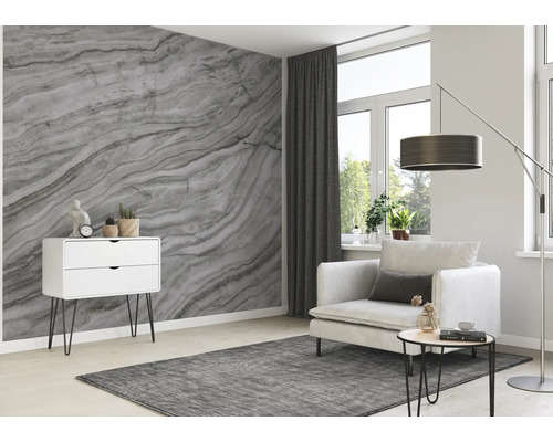 Wohnzimmer mit Marmortapete, Sessel, Kommode und Teppich für eine helle, moderne Atmosphäre